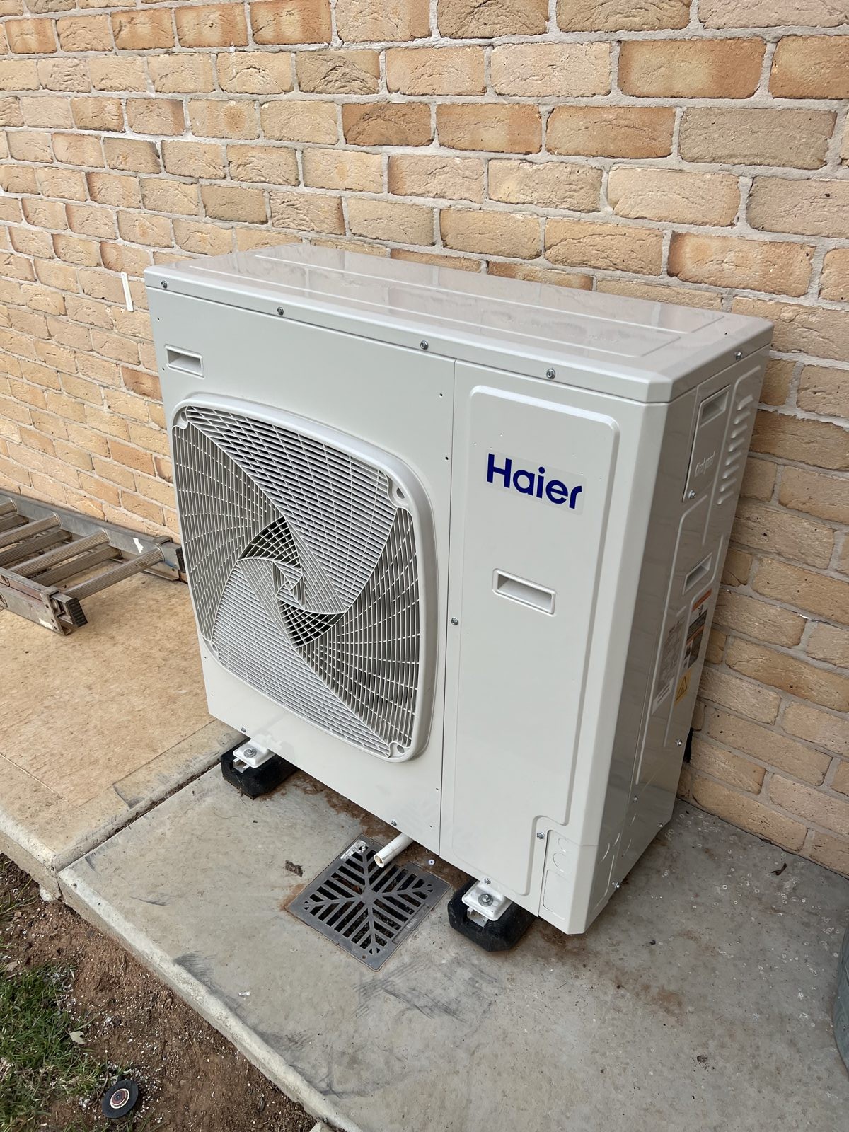 Haier condenser unit on a brick wall